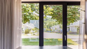 A room with a large window overlooking a residential street. - Houseboat With Private Roofed Terrace (Zeewolde)