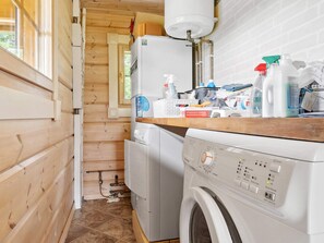 Ein Waschraum mit Waschmaschine, Trockner und Warmwasserbereiter.
