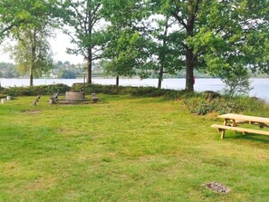 A grassy park area with picnic tables and a fire pit. - 4 Star Holiday Home in Boras (Borås)