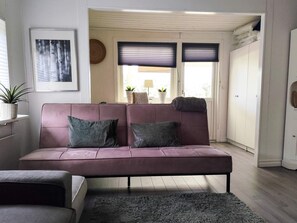 A living room with a sofa, a rug, and a potted plant. - 4 Star Holiday Home in Boras (Borås)
