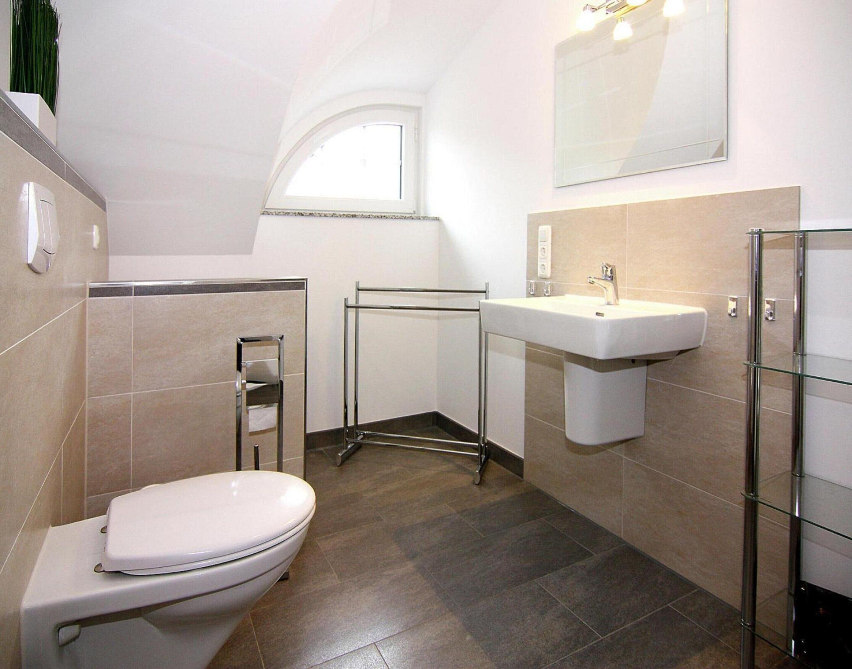 A modern bathroom with a toilet, a sink, and a shower area.