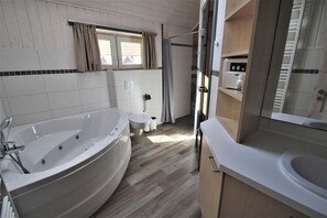 A modern bathroom with a freestanding bathtub, a toilet, and a sink. - Skandinavisches Ferienhaus in Mirow (Mirow)
