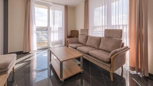 Una sala moderna con un sofá, una mesa de centro y vistas a un balcón.