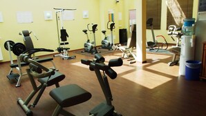 A gym with various exercise equipment including treadmills, stationary bikes, and weight machines.