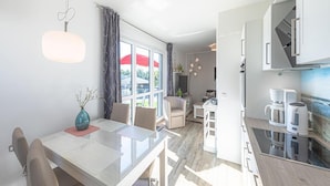 A modern kitchen with a dining area, large windows, and a view of the outdoors. - Liebevoll Eingerichtetes Appartement (Rechlin)