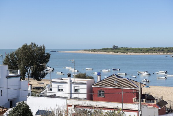 Une vue sur la côte, avec des bâtiments, une plage et des bateaux.