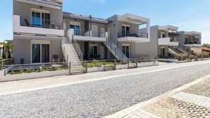 A modern multi-story residential building with balconies, staircases, and a gravel driveway. - Amarylis Residential Complex-One Bedroom Apartment (Kavala)