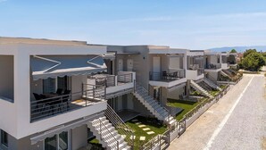 A modern hotel with multiple balconies, a central staircase, and a paved walkway. - Amarylis Residential Complex-One Bedroom Apartment (Kavala)