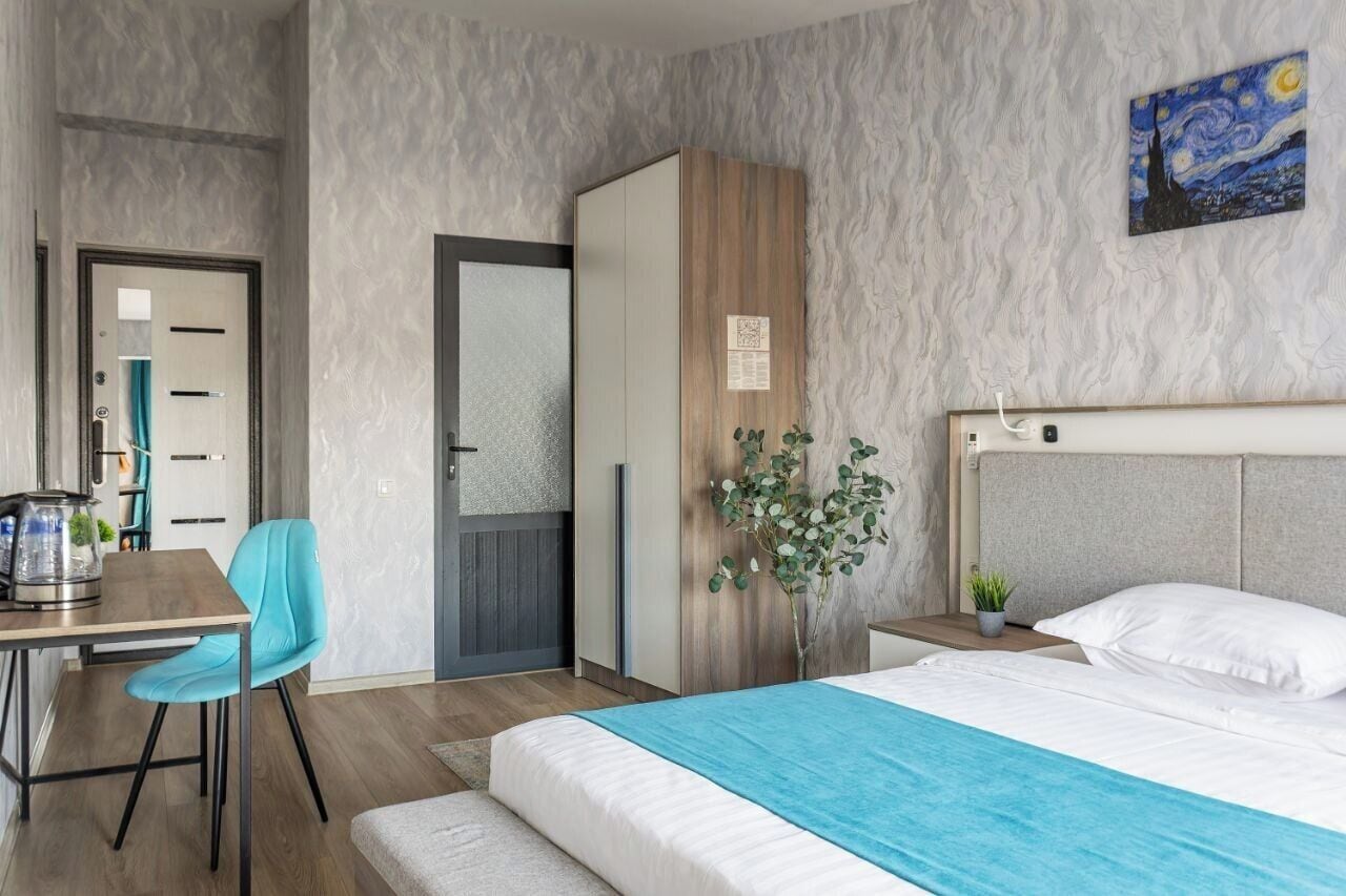 Un dormitorio moderno con cama, escritorio y armario.