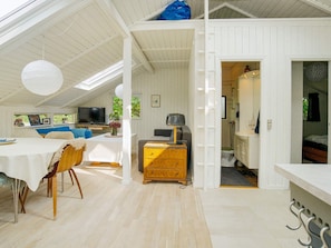 A modern interior with a dining area, a sofa, a television, and a bathroom visible through an open door. - 4 Person Holiday Home in Gilleleje (Gilleleje)