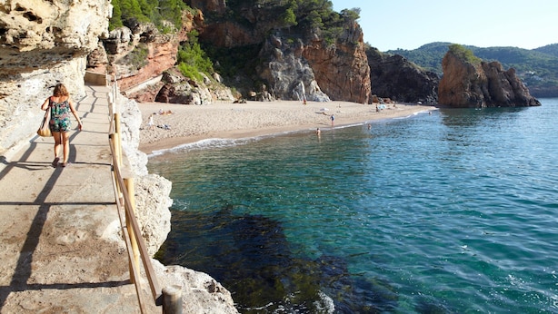 A coastal walkway leading to a beach with clear water, rocky cliffs, and greenery. - Bungalow Near Pals Beach With Pool (Pals)