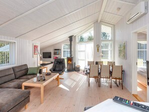 Un salon spacieux avec une cheminée, un canapé, une table basse et un téléviseur.