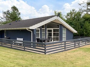 A single-story building with a covered patio area, a fenced deck, and a large windowed front section. - 4 Star Holiday Home in Logstor (Logstor)