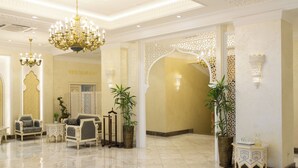 Eine Lobby mit einer Chandelier, einer Sitzecke und einem Schild, das ein Restaurant anzeigt.