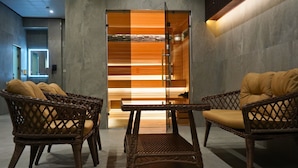 A modern lobby with wicker furniture and a central table, featuring a unique lighting design on the back wall. - Al Anvar Hotel (Tashkent)