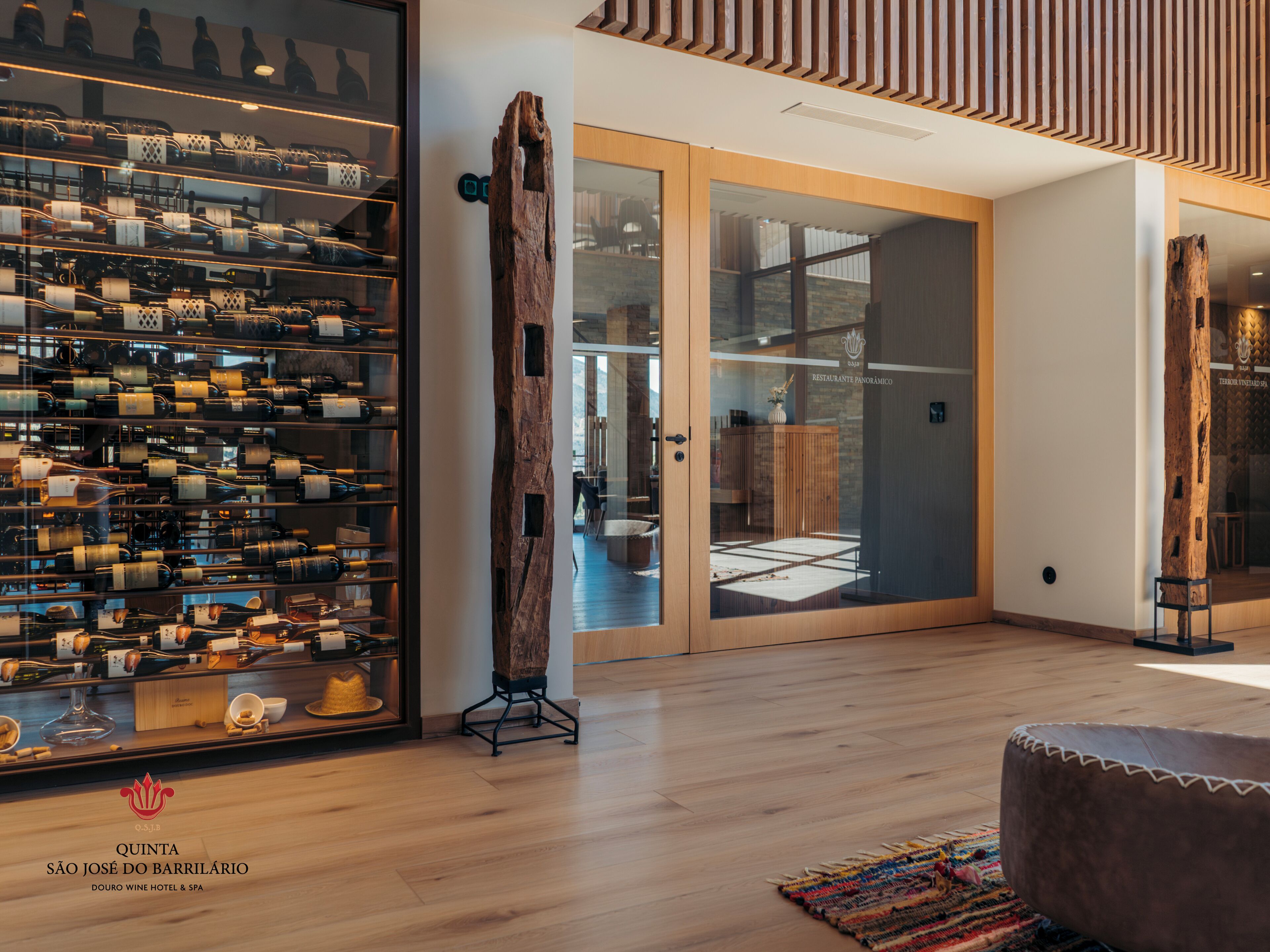 Un interior moderno con una cava de vinos, detalles de madera y vistas a un comedor.