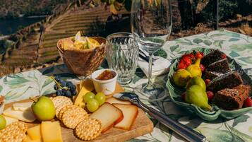Una mesa dispuesta con queso, galletas, uvas y un bol de fruta.