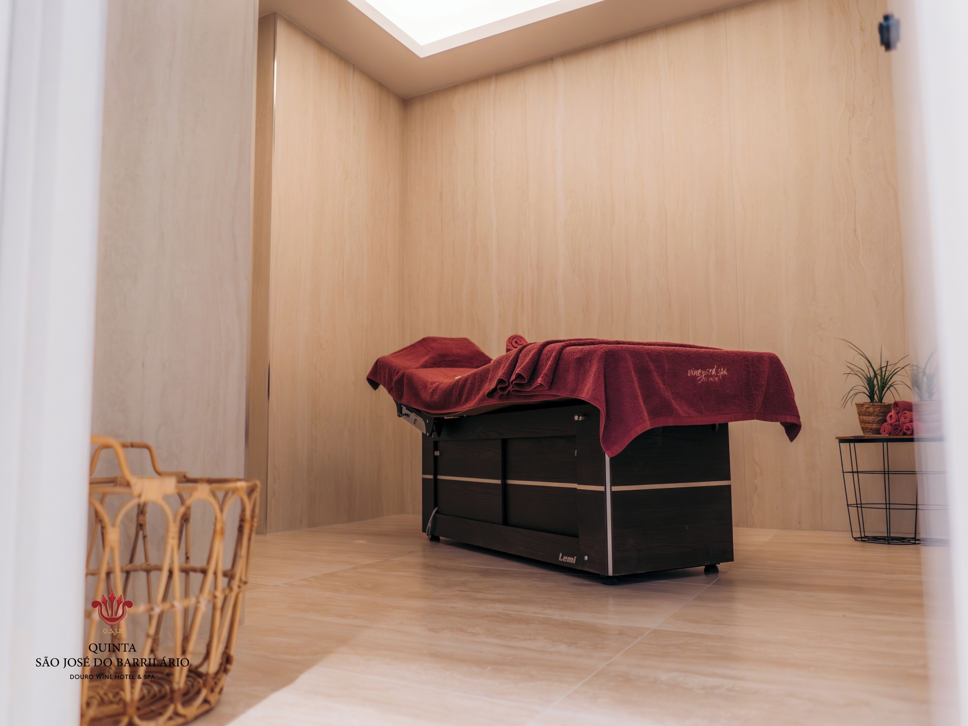 A massage table in a room with wooden walls and a tiled floor.
