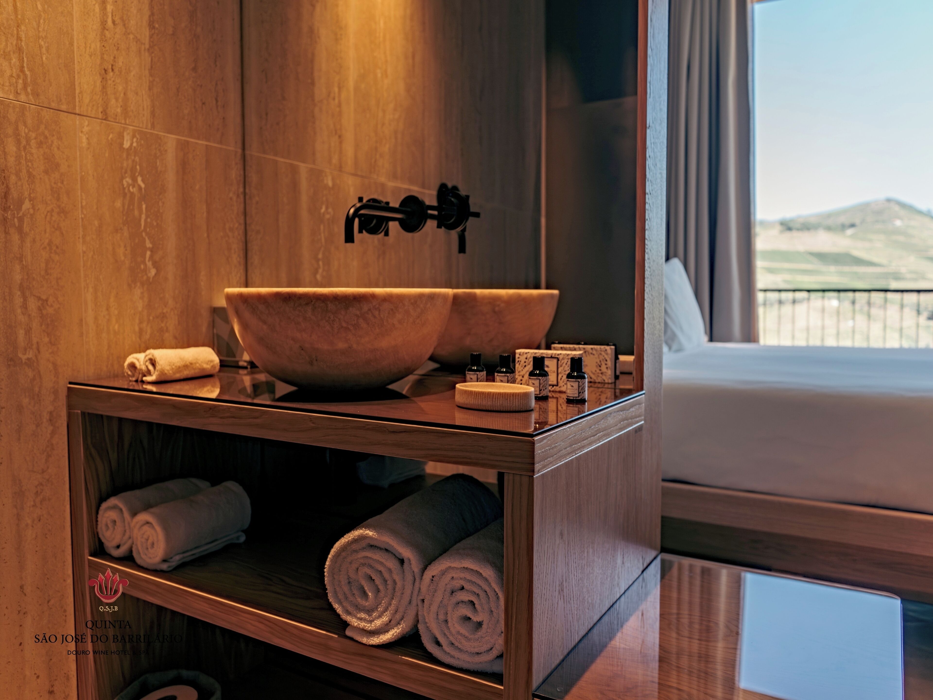 Un baño con tocador de madera, un lavabo grande y toallas.