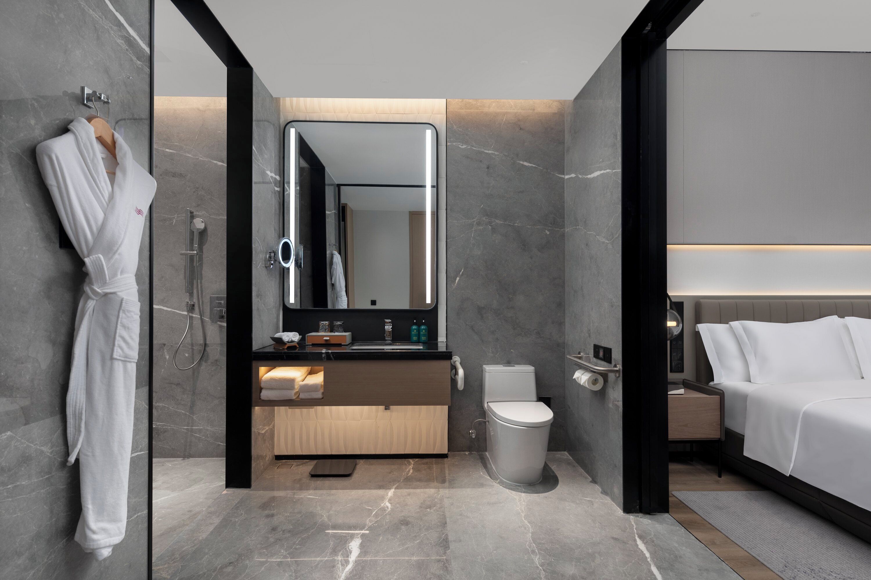 A modern bathroom with a glass shower enclosure, a vanity with a mirror, and a separate toilet.