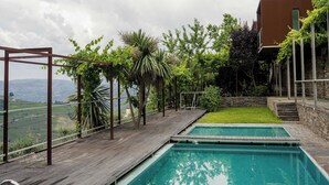 A wooden deck with a swimming pool, surrounded by greenery and a view of the countryside. - Vila Marim Country House (Mesão Frio)