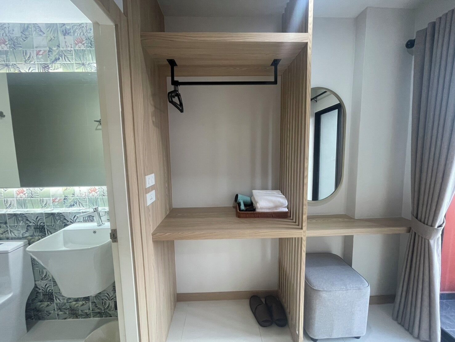 A compact bathroom with a toilet, sink, and a small vanity area with a mirror.