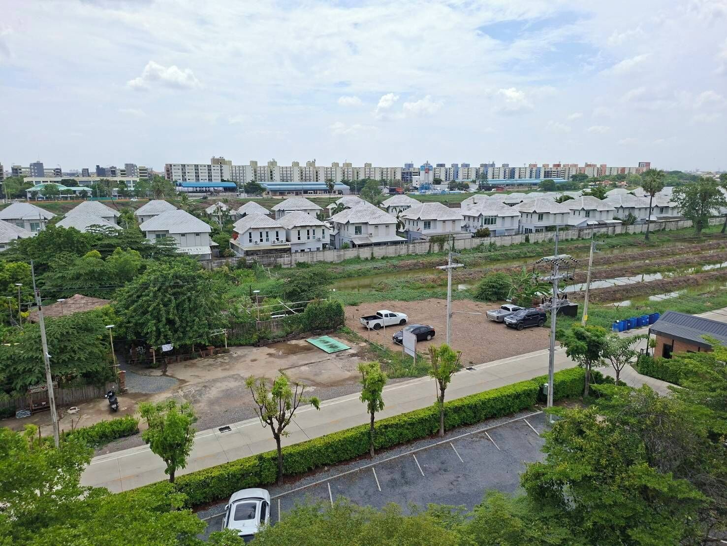 Zona residencial con casas de varios pisos, un estacionamiento y una calle.