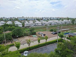 Zona residencial con casas de varios pisos, un estacionamiento y una calle.