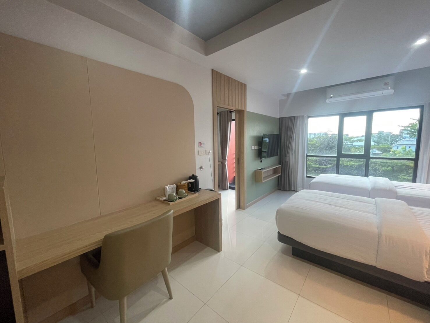 Une chambre d’hôtel moderne avec un grand lit, un bureau et une télévision.