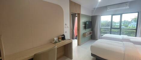 Une chambre d’hôtel moderne avec un grand lit, un bureau et une télévision.