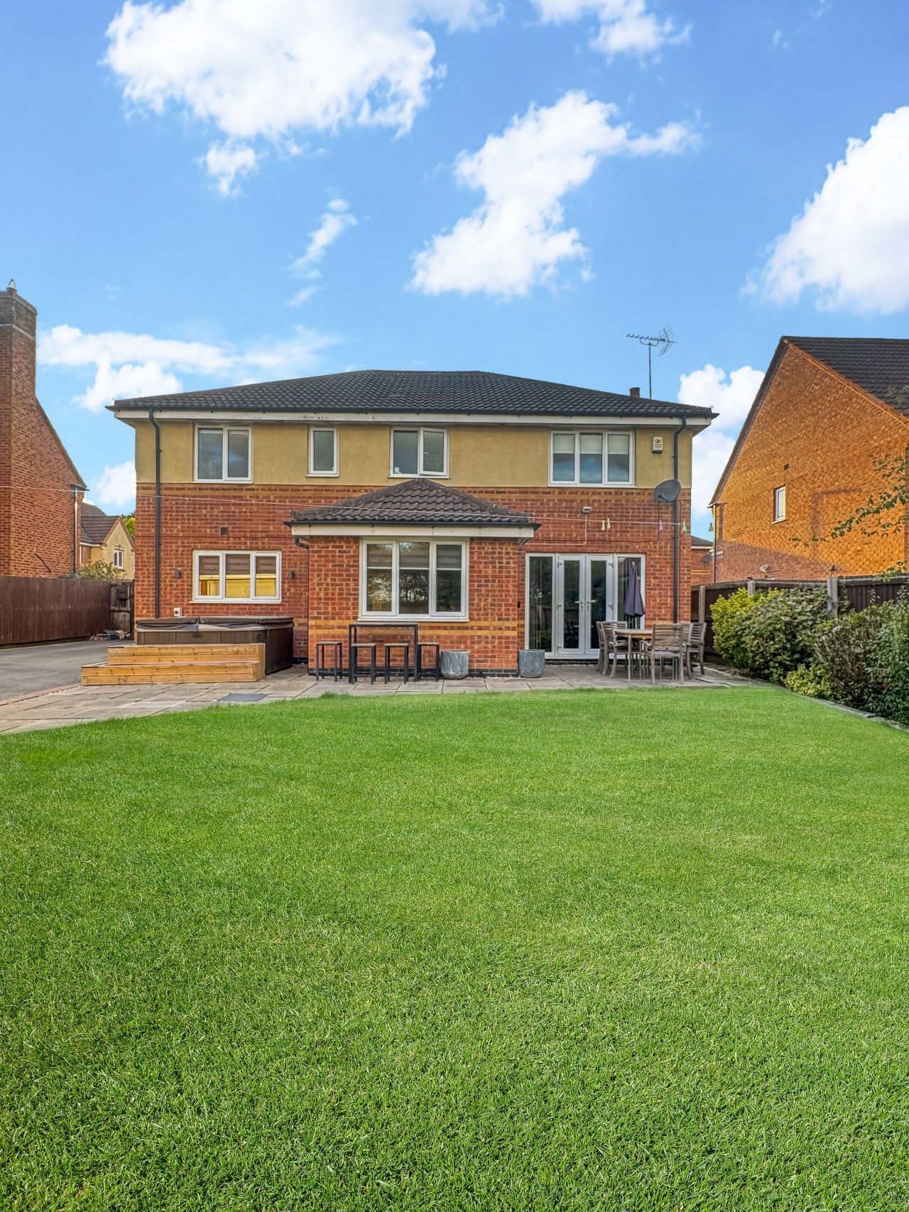 A two-story residential house with a well-maintained lawn in the front yard.