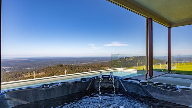 A hot tub with a panoramic view of a landscape, including hills and a clear sky. - Petrichor Estate - 360 Views, Magnesium Pool & Spa (Sunshine Coast Hinterland)