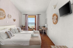 A hotel room with two beds, a TV, a desk, and a view of the sea. - Iliessa Beach Hotel by GHH (Zakynthos)