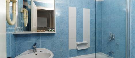 A bathroom with a sink, mirror, and shower.