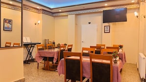 A conference room with a long table, chairs, a piano, and a TV on the wall. - Esen Life Hotel  (Istanbul)