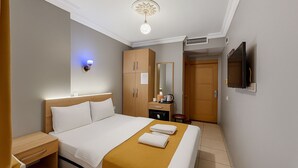 A hotel room with a bed, bedside table, wardrobe, mirror, and a television mounted on the wall. - Esen Life Hotel  (Istanbul)