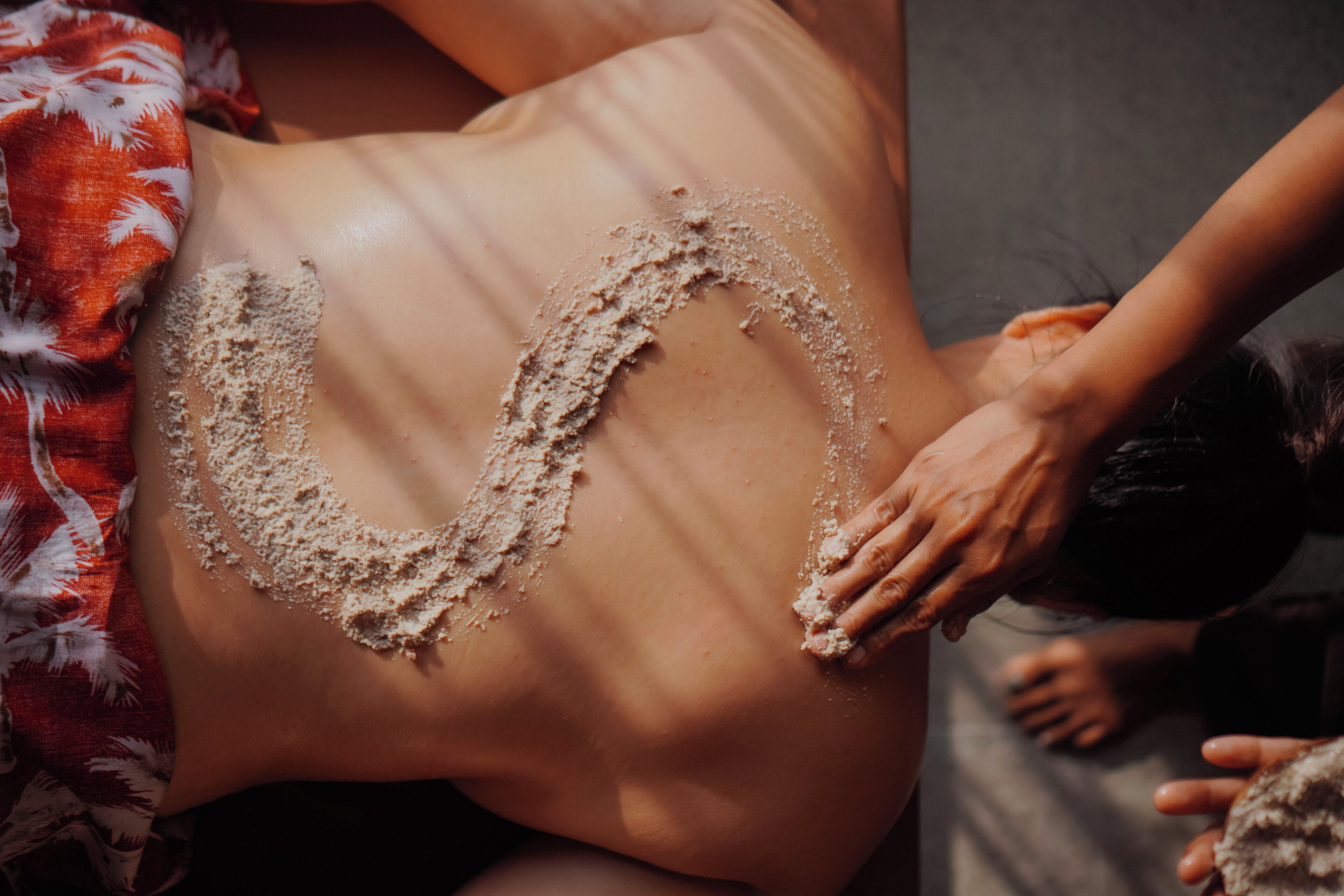 Eine Person, deren Bauch mit Sandskulptur verziert ist.