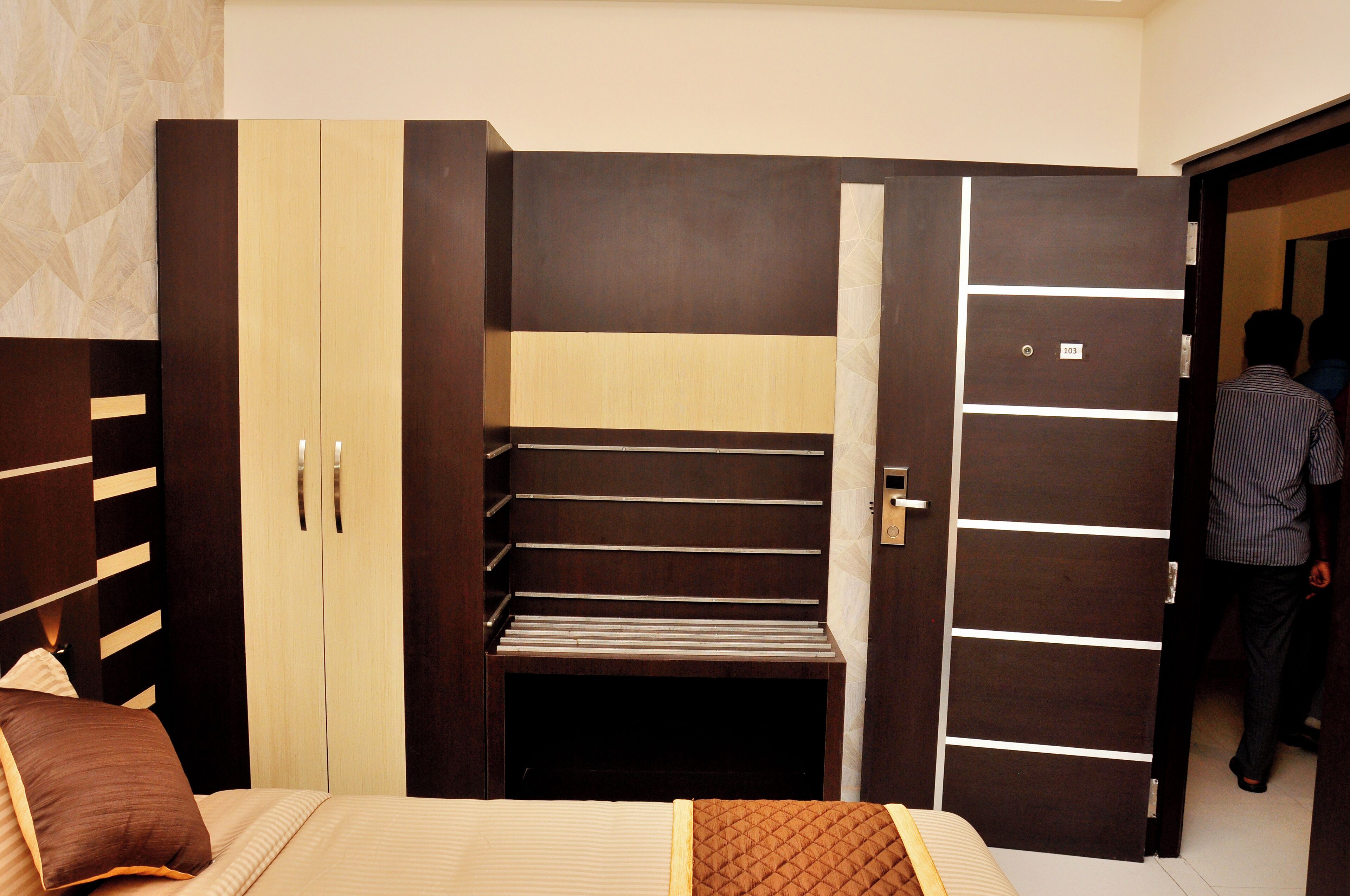 Un dormitorio con cama, armario y estantería empotrada.
