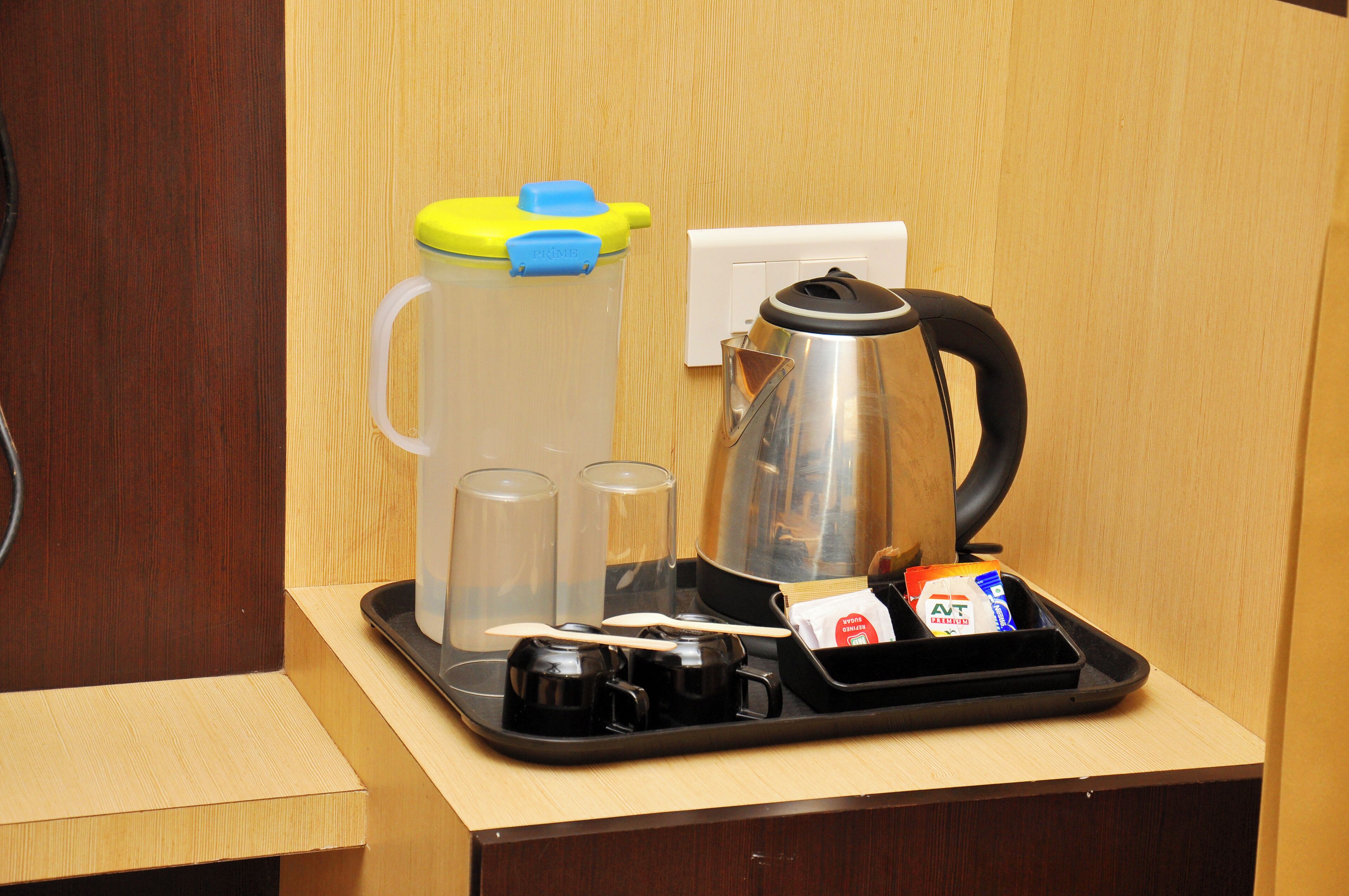 Ein Kaffee-Bereich mit Kaffeemaschine, Milchaufschäumer, Tassen und Zutaten.