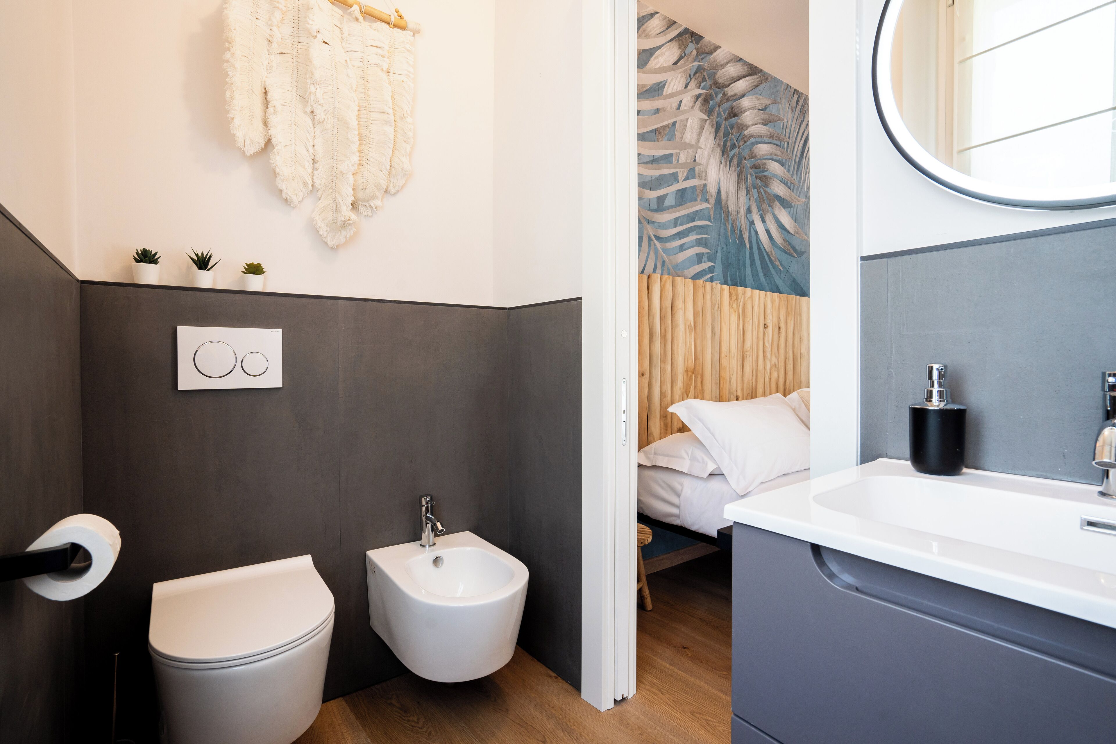 A modern bathroom with a bidet, toilet, and sink.