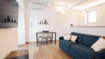 Loft Comfort, vista mare | Area soggiorno | TV a schermo piatto 32 pollici con canali via cavo, servizi in streaming