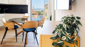 A modern kitchen with a dining area, large windows, and a view of the city. - CADAMARE charming rooms in Portovenere (La Spezia)