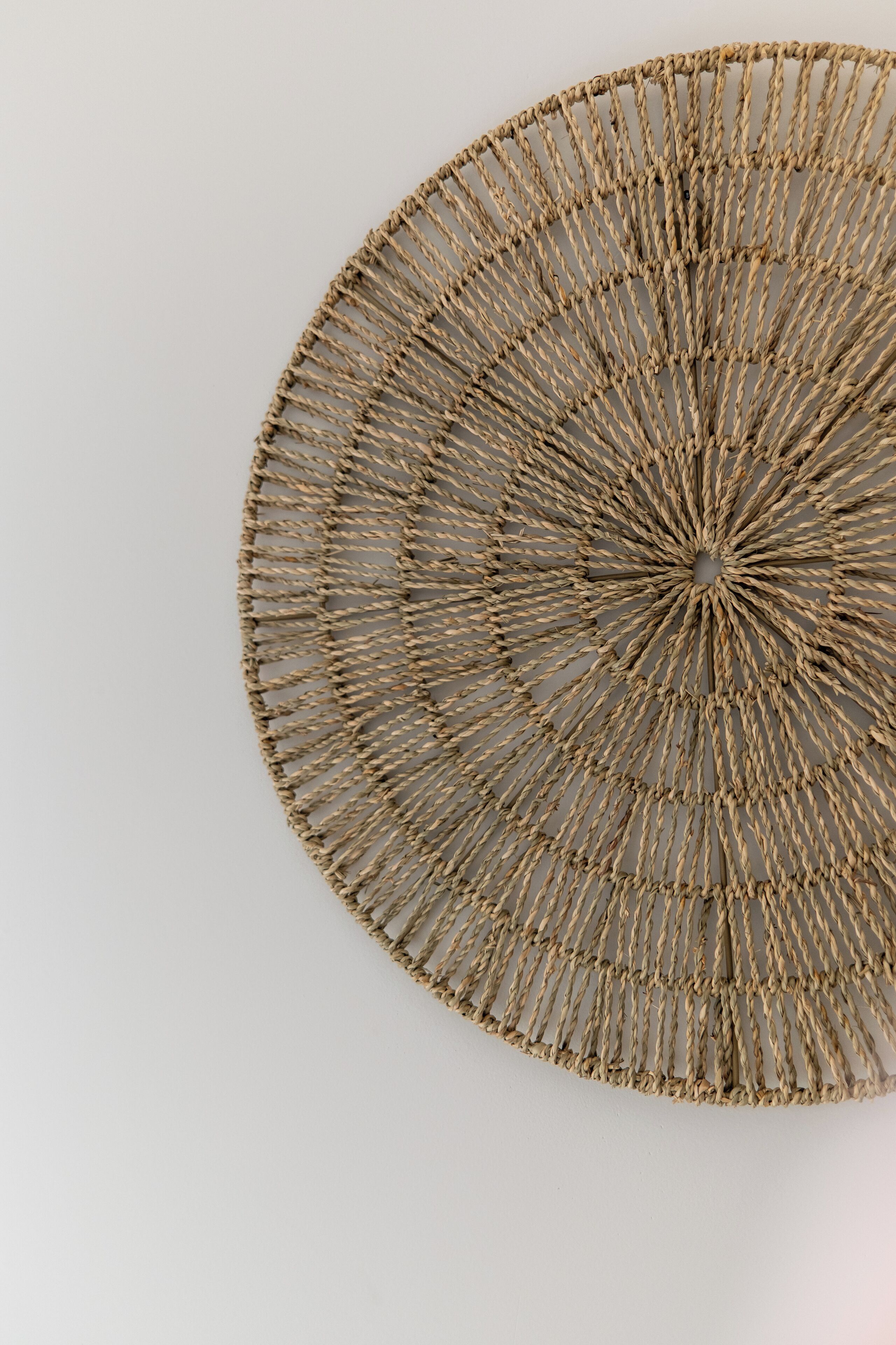 A circular woven wall hanging with a central knot.