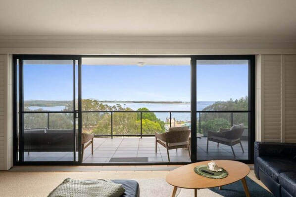 A room with a large sliding glass door leading to a balcony with outdoor furniture.