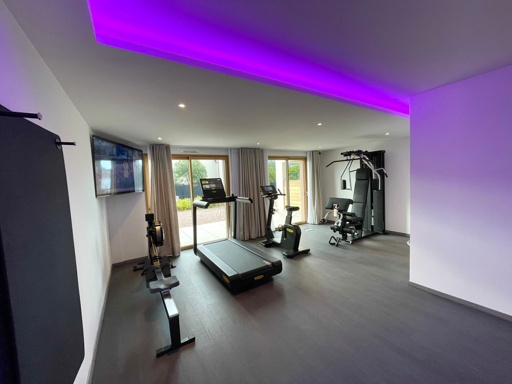 A modern home gym with exercise equipment, a treadmill, and a stationary bike.