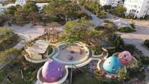 An aerial view of a park with colorful dome-shaped structures, pathways, and surrounding greenery. - Zanzibar FumbaTown B08-02-12 (Fumba)