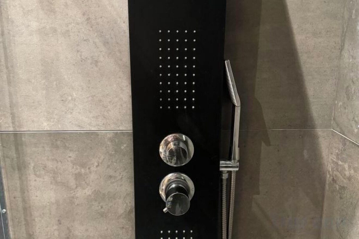 Brusekabine med kontrolpanel og håndbruser.