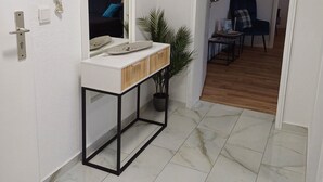 A modern bathroom with a white vanity, a mirror, and a potted plant. - Apartment Busch in the center (Bad Harzburg)
