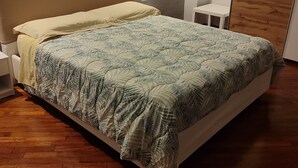 Un dormitorio con cama, mesita de noche y armario.