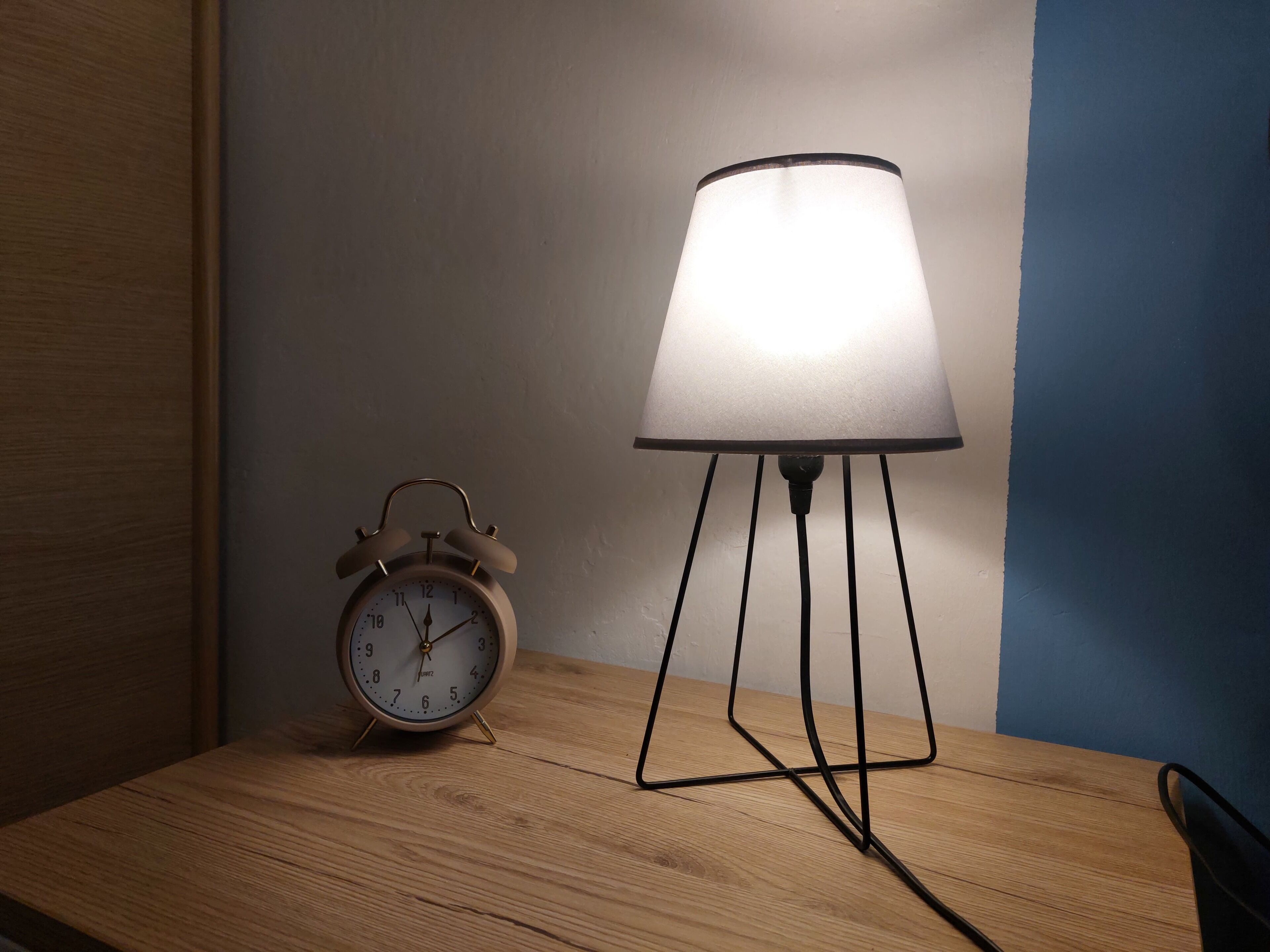 Ein Holztisch mit einer Wanduhr und einer Tischlampe.